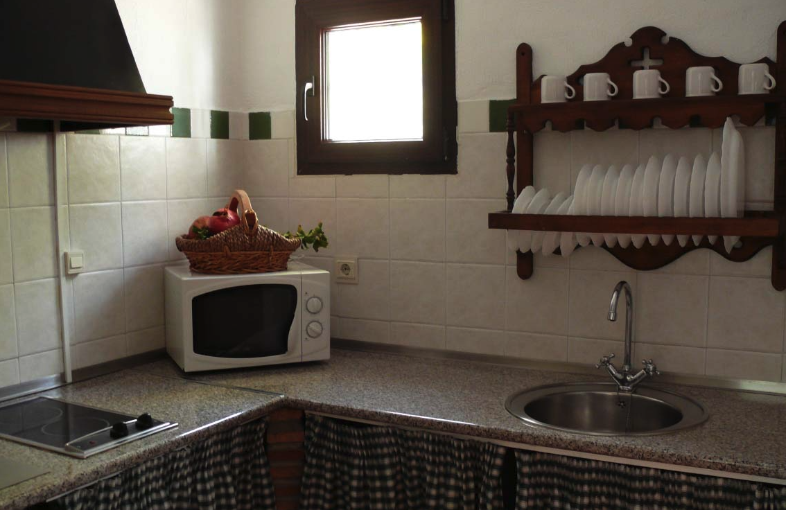 Interior de una casa que cuenta con un sofá, una mesa de café. Se ve en la imagen un radiador bajo una ventana.